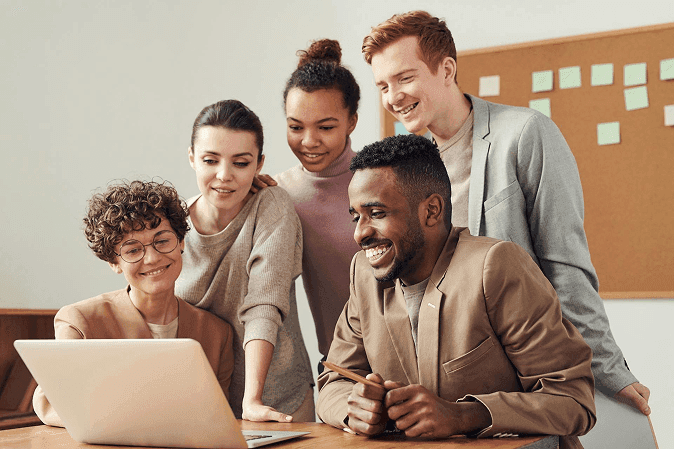 Team collaborating with a laptop in a bright office